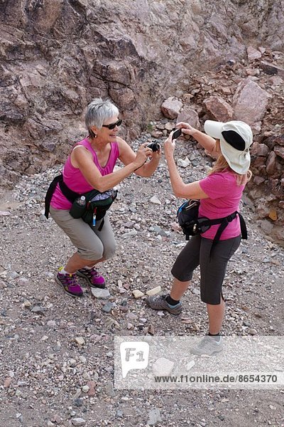 Zwei ältere Wandererinnen  die sich gegenseitig fotografieren.