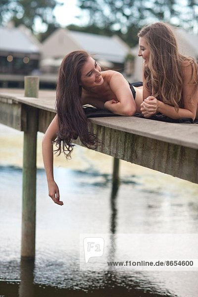 Zwei junge Frauen entspannen sich am Flussufer