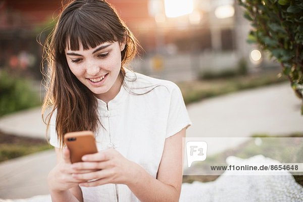 Junge Frau beim SMSen auf dem Handy