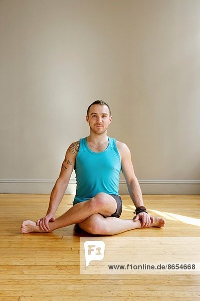 Mann in Kuhgesicht-Yoga-Pose