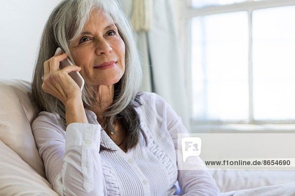 Porträt der attraktiven Seniorin im Chat auf dem Smartphone