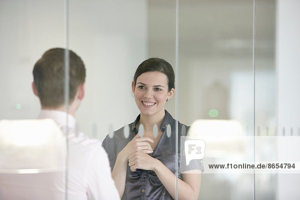 Business colleagues in discussion through glass