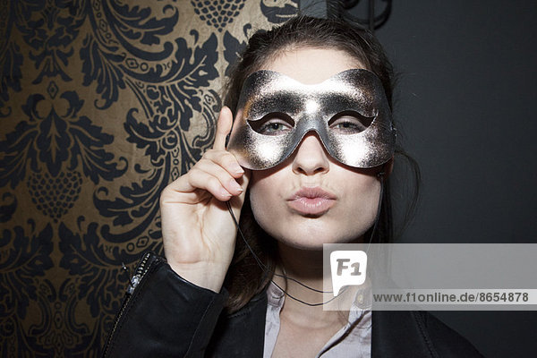 Frau mit Partymaske  Lippen schürzen  Porträt