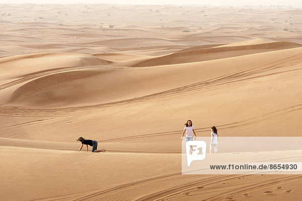 Kinder wandern auf Düne in der Wüste