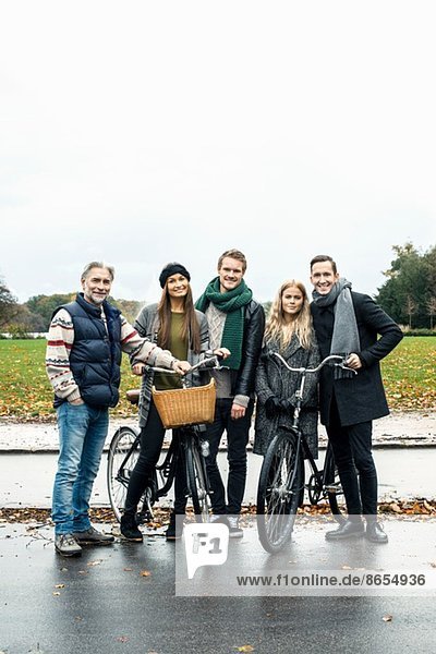 Freunde posieren mit dem Fahrrad auf der Straße
