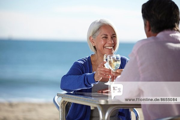 Paar genießt Wein am Meer