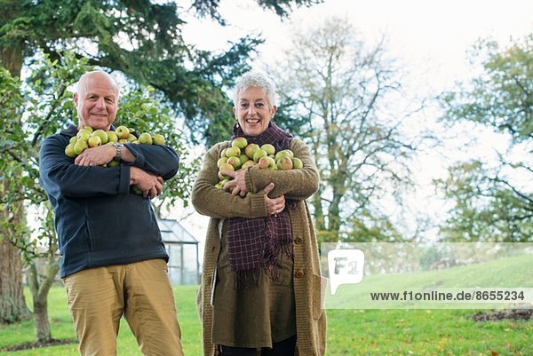 Glückliches Seniorenpaar mit Äpfelarm