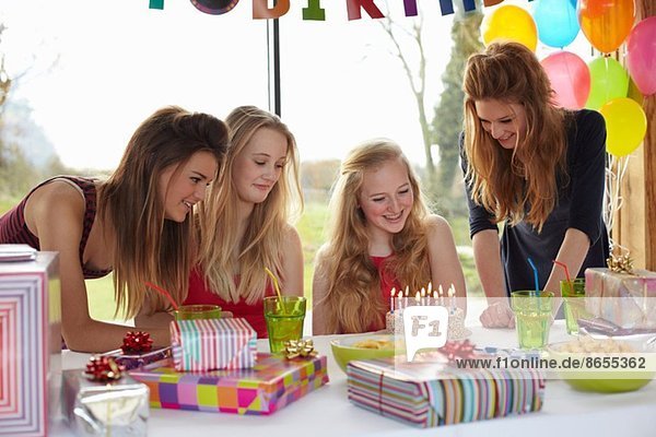 Teenagermädchen teilt Geburtstagstorte mit Freunden