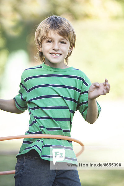 Junge spielt mit Hula Hoop im Hof
