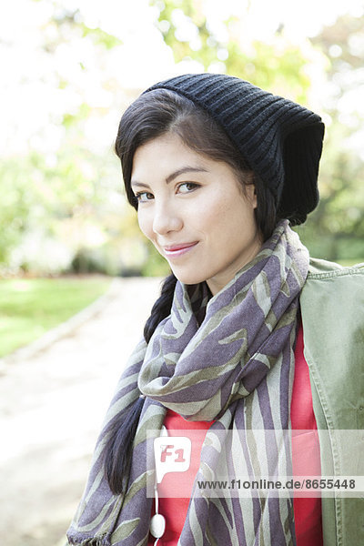Young woman wearing knit hat and scarf  smiling  portrait