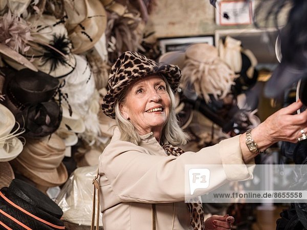 Glamouröse Seniorin beim Blick auf Hüte