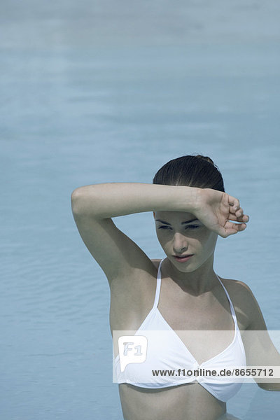 Junge Frau in Schwimmbadabschirmung Augen