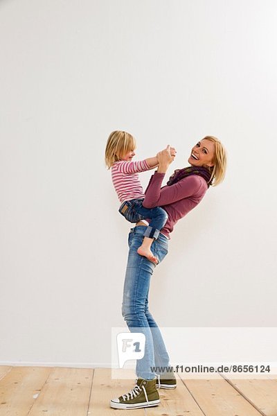 Studio portrait of mother playing with young daughter