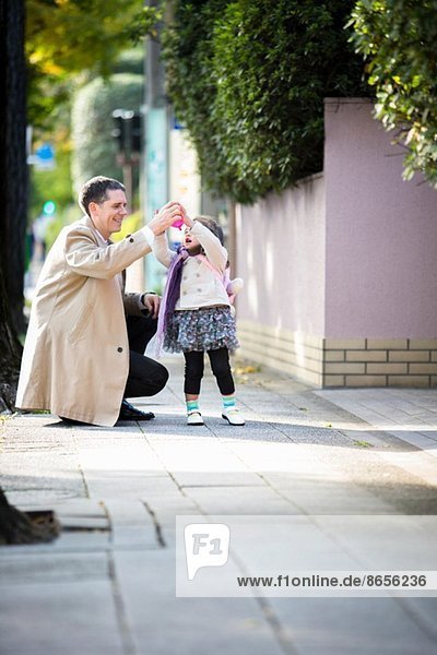 Vater und Tochter auf dem Bürgersteig