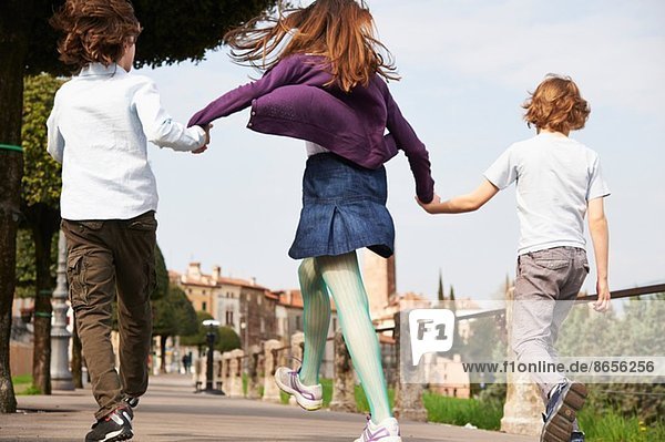 Junge Jungen und ältere Schwester marschieren durch den Park  Provinz Venedig  Italien