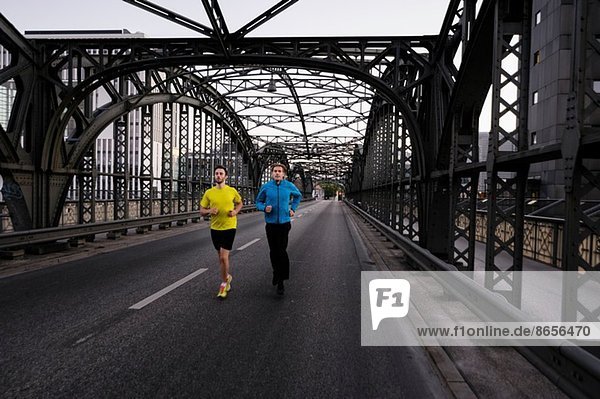 Zwei Männer rennen über die Stadtbrücke