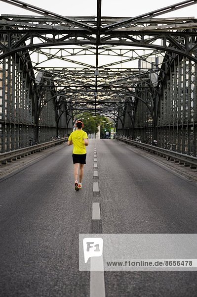Junger Sportler  der über die Brücke läuft