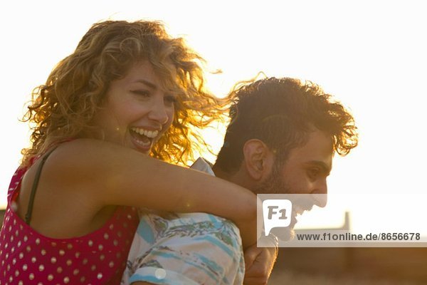 Young couple hugging in sunlight
