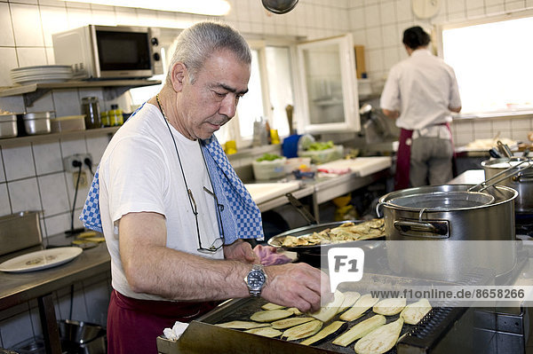Chef roasting aubergines for an antipasti dish  Italian restaurant  ristorante  Munich  Upper Bavaria  Bavaria  Germany