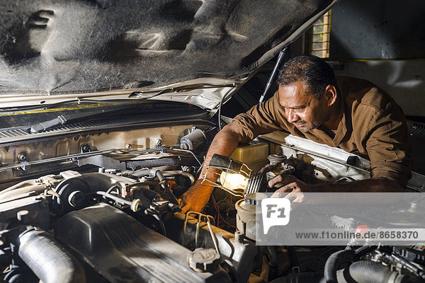 Ein Kfz-Mechaniker repariert einen BMW in einer Garage  Fort  Mumbai  Maharashtra  Indien