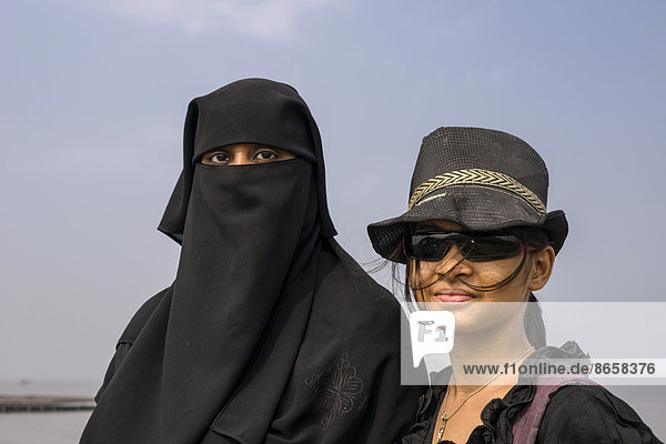 Zwei muslimische Frauen  eine im traditionellen schwarzen Tschador  die andere in westlicher Kleidung  Mumbai  Maharashtra  Indien