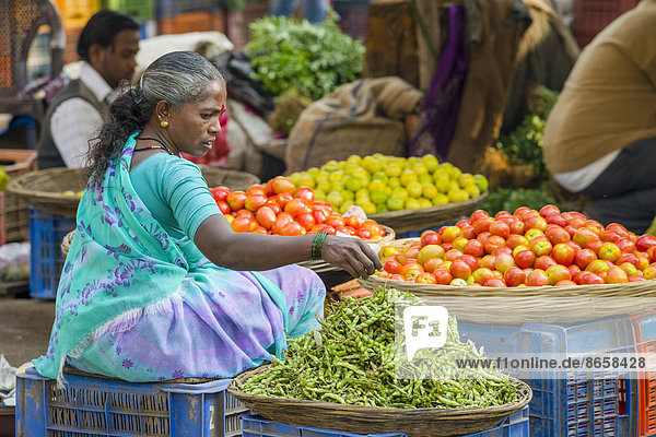 Eine Frau verkauft Chilischoten und Tomaten auf dem wöchentlichen Gemüsemarkt  Nasik  Maharashtra  Indien