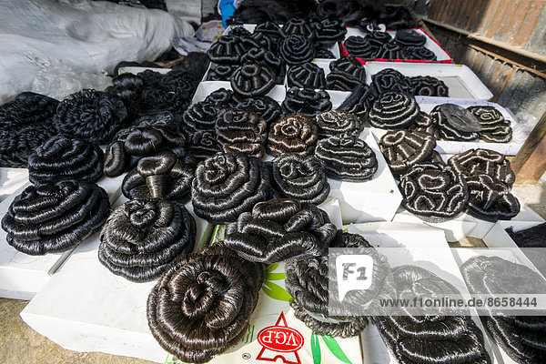 Künstliche Haare  zu Haarknoten geflochten  zum Verkauf auf dem Wochenmarkt  Nasik  Maharashtra  Indien