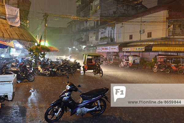 Street scene with a flooded road during heavy monsoon rain at night  city centre  Phnom Penh  Cambodia