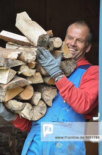 Smiling man carrying firewood Ronneby Blekinge Sweden