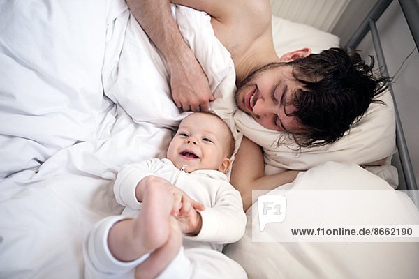Father with baby son in bed  London  United Kingdom