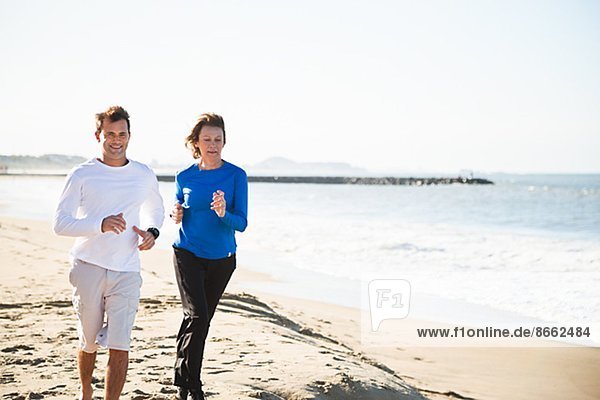Woman and man running on beach