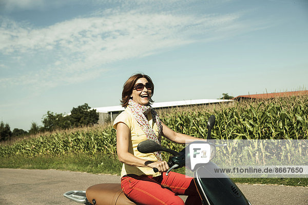 Frau fährt auf einem Roller