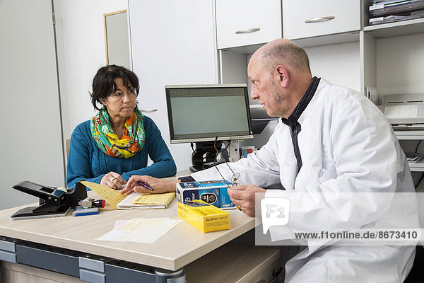Medical practice  doctor talking to a diabetes patient about the use of blood glucose meters  Germany