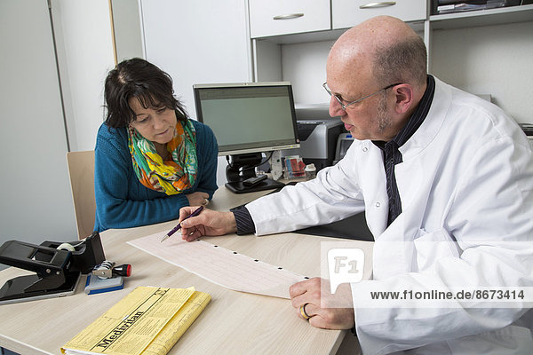 Medical practice  doctor talking to a patient about an ECG finding  Germany