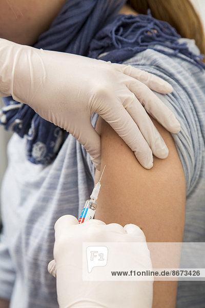 Junge Frau bekommt eine Grippeschutzimpfung  Vaxigrip  Deutschland