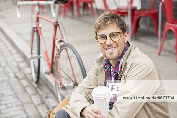 Mann trinkt Kaffee auf der Stadtstraße