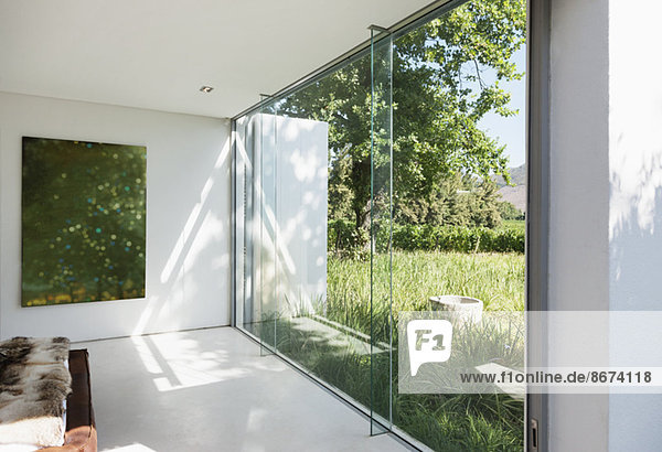 Modernes Haus mit Glaswänden mit Blick auf das Gras