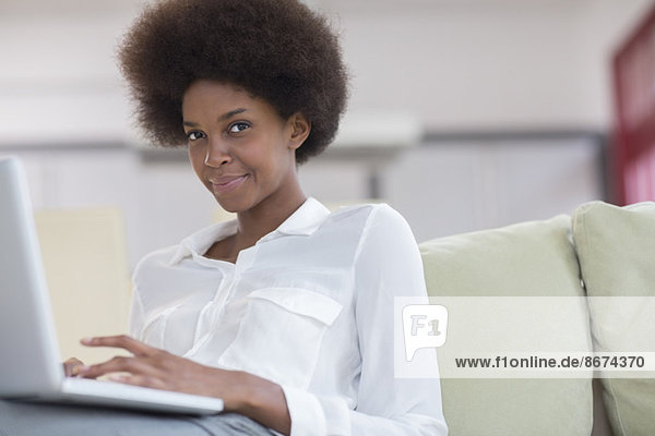 Businesswoman using laptop on sofa
