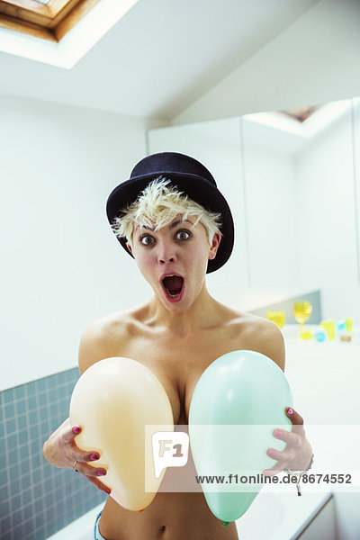 Woman covering breasts with balloons