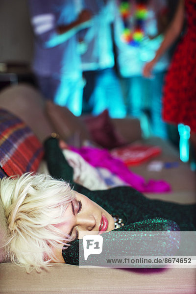Woman sleeping on sofa at party