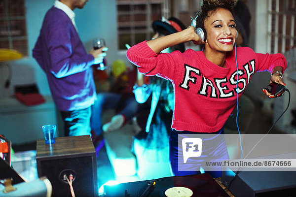Woman playing music and dancing at party