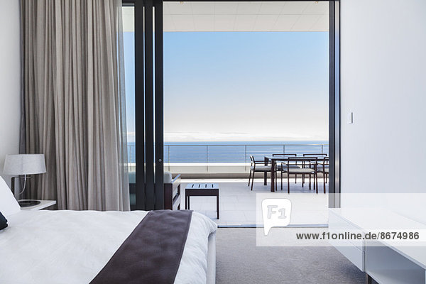 Modern bedroom and balcony overlooking ocean