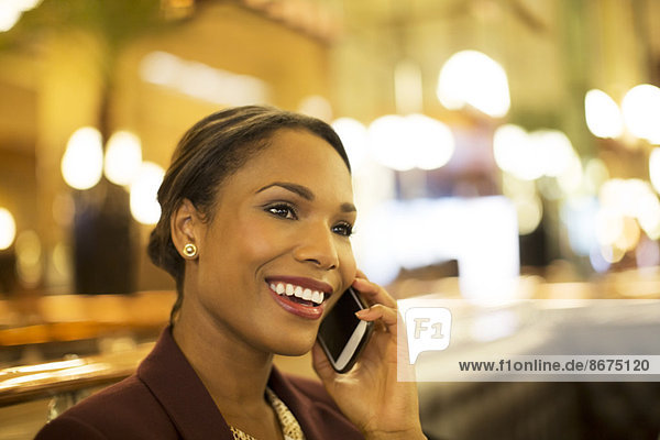 Businesswoman talking on cell phone in restaurant