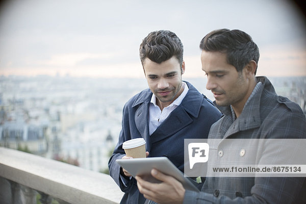 Geschäftsleute mit digitalem Tablett mit Paris,  Frankreich im Hintergrund