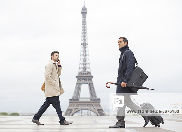 Businessmen walking past Eiffel Tower  Paris  France