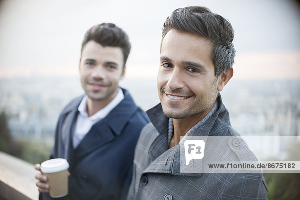 Businessmen smiling with city in background
