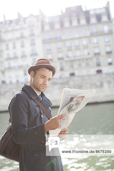 Geschäftsmann beim Zeitungslesen entlang der Seine  Paris  Frankreich
