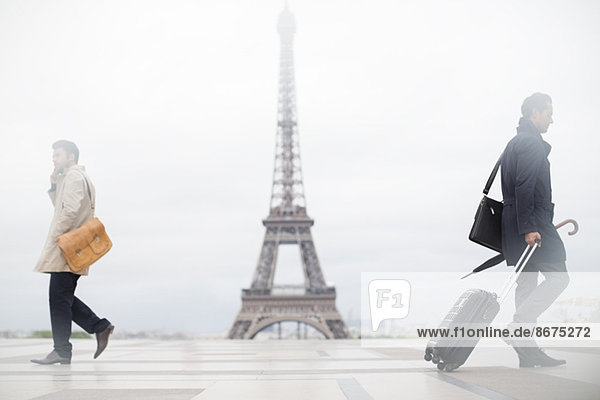 Geschäftsleute gehen am Eiffelturm vorbei,  Paris,  Frankreich
