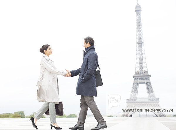 Business people shaking hands near Eiffel Tower  Paris  France