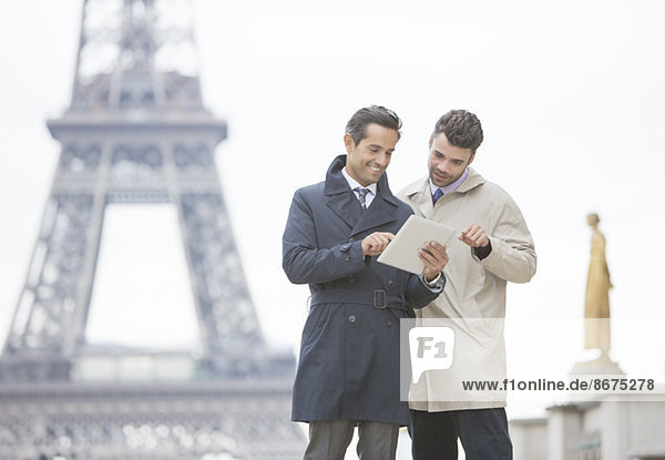 Geschäftsleute mit digitalem Tablett am Eiffelturm,  Paris,  Frankreich
